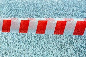 broken glass background with red and white ribbon. Danger sign and stop photo