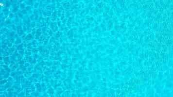 Blue water in the swimming pool with light reflections. Aerial footage video