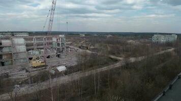 FPV drone flies smoothly among abandoned industrial buildings and around an excavator video