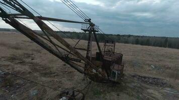 FPV drone flies maneuverable near rusty abandoned walking excavator video