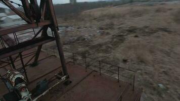 FPV drone flies maneuverable near rusty abandoned walking excavator video