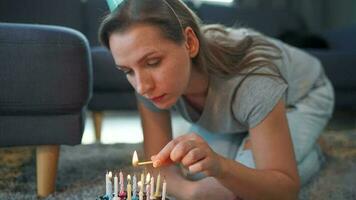 mujer Encendiendo velas en cumpleaños pastel, celebrando cumpleaños a hogar video