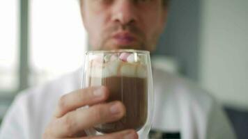 Man drinking cocoa with marshmallows. Close-up video