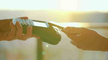 Close-up, man using smartphone cashless wallet NFC technology to pay order on bank terminal. Card machine in female hand video