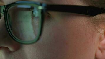 Woman in glasses looking on the monitor and and working with charts and analytics. The monitor screen is reflected in the glasses. video