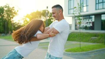 Daughter runs to dad and hugs him. Father picks up the child in his arms video