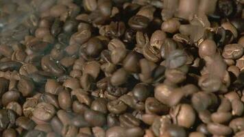 slow motion van gebrande koffiebonen vallen. biologische koffie zaden. video