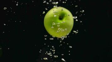 manzana, de cerca de manzana fruta, lento movimiento, lento movimiento de verde manzana en agua. verde manzana que cae dentro el agua video