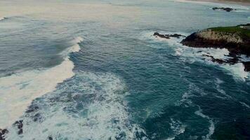 asombroso ver de grande Oceano olas que se acerca el acantilado apuntalar en arteixo, España. aéreo, pan Disparo video