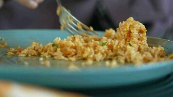 comiendo cocido arroz en plato en mesa, cerca arriba video
