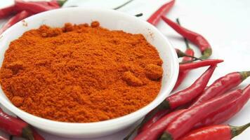 Chili powder and red peppers on table background video
