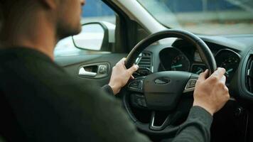 Man driving in innovative automated car using self-parking autopilot for parking on parking lot video