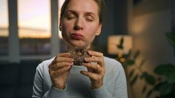 Sweet addiction concept. Woman eats chocolate donut with morbid rapture video