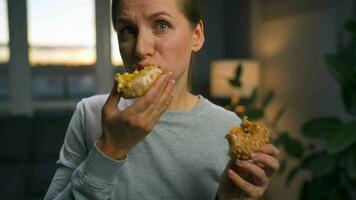 Saufgelage Essen Konzept. kaukasisch Frau mit Essen Störung Essen zwei Donuts schnell und beim das gleich Zeit video