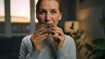 doce vício conceito. mulher come chocolate rosquinha com mórbido êxtase video