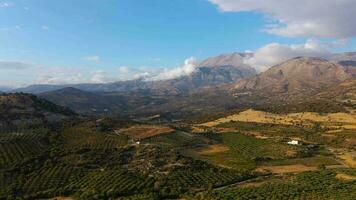 aéreo ver de Creta isla, Grecia. montaña paisaje, aceituna arboledas, nublado cielo en puesta de sol ligero video