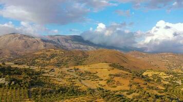 aéreo ver de Creta isla, Grecia. montaña paisaje, aceituna arboledas, nublado cielo en puesta de sol ligero video