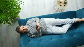 Woman in wireless headphones listening to music and using mobile apps or communicates on social networks on smartphone video