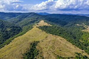 Panoramic Drone Aerial View view of mountain peaks. Hilltops covered with forest. Green nature background aerial view mountain landscape. photo