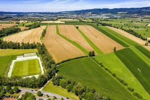 Aerial view from drone of the countryside with a football field and beautifully cultivated fields in Germany photo