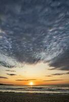 Beautiful sea sunset or sunrise with amazing clouds. Vertical view photo