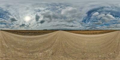 spherical 360 hdri panorama on gravel road with clouds on overcast sky in equirectangular seamless projection, use as sky replacement in drone panoramas, game development as sky dome or VR content photo