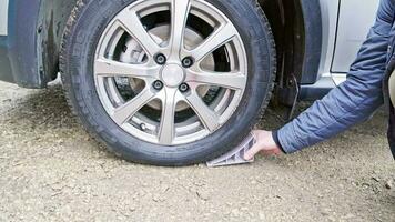 person removing wheel chock out from wheel of civil vehicle tire video