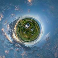 little planet transformation of spherical panorama 360 degrees overlooking church in center of globe in blue sky. Spherical abstract aerial view with curvature of space. photo