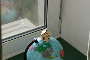 House mockup stands on world map globe photo