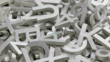 full frame close-up looped rotating background of silver metal letters with selective focus video