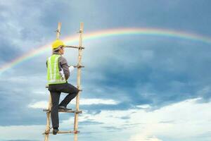 Asian business man engineer climbing up ladder with blue sky, career growth and success concept photo