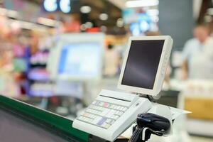 Empty cashier checkout desk with terminal in supermarket photo