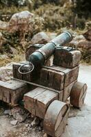 An old fashioned cannon with a wooden carriage and a cast iron barrel for firing cannonballs photo