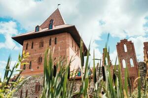 Fortress wall and red brick tower in medieval style - defensive fortification photo