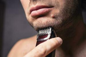 Close-up Caucasian middle-aged man smoothes his stubble photo