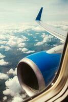 The engine and wing of an airplane in the sky during flight - the view from the airplane window to the ground before landing photo