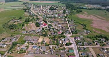 flying over road in a village with sheds and garden plots video