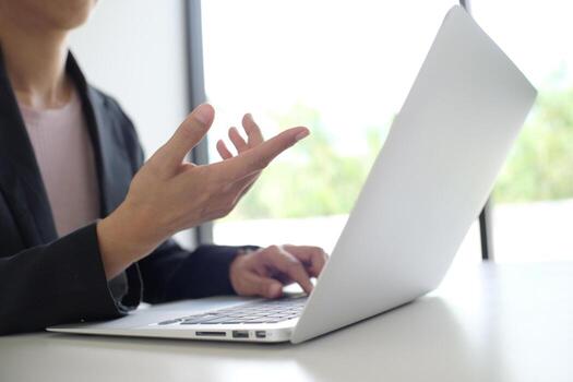 Man working by using a laptop computer on wooden table. Hands typing on a keyboard photo