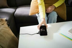 cargando móvil teléfono batería con inalámbrico cargando dispositivo en el mesa. teléfono inteligente cargando en un cargando almohadilla. móvil teléfono cerca inalámbrico cargador moderno estilo de vida tecnología concepto. foto