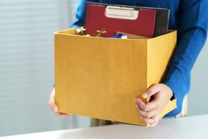 Quit Job Business man sending resignation letter and packing Stuff Resign Depress or carrying business cardboard box in office. Change of job or fired from company. photo