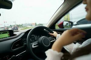 mujer conducción coche. niña sensación contento a conducir participación direccion rueda y mirando en la carretera foto