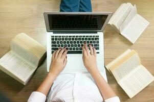 Top view girl sitting on the floor and working with laptop or notebook, playing game online or shopping online concept, learn or education via internet photo