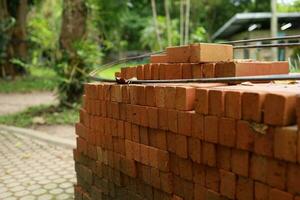 paleta un rojo ladrillo edificio material apilar de nuevo rojo ladrillos para construcción. foto