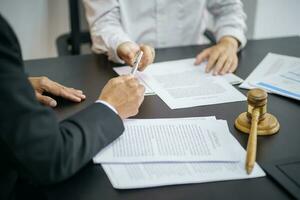 El asesor legal presenta al cliente un contrato firmado con mazo y ley legal. concepto de justicia y abogado foto