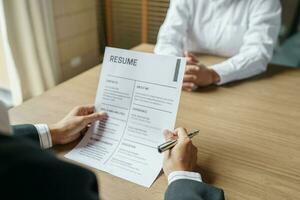 Examiner reading a resume during job interview at office Business and human resources concept photo