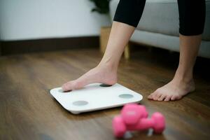 Fat diet and scale feet standing on electronic scales for weight control. Measurement instrument in kilogram for a diet control photo