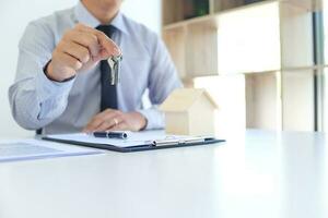 Sales manager giving advice application form document, considering mortgage loan offer for car and house insurance. photo