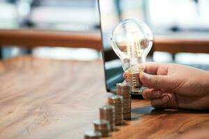 saving coins idea with light bulb for investment Concept idea and innovation. photo