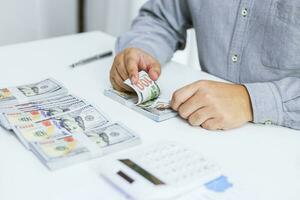 Businessman analyzing investment charts and pressing calculator buttons over documents. Accounting Concept. photo