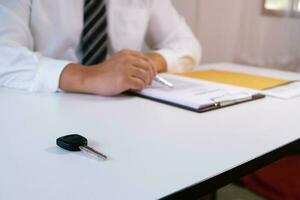 Car salesman handing over the keys for a new car. photo